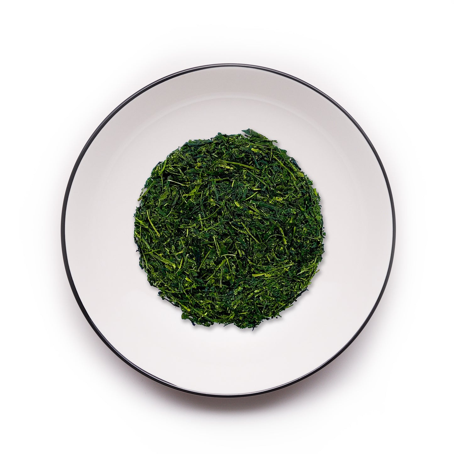 Premium Kyoto Uji Fukamushicha tea leaves from MAISON TOMOKI on a white plate with a black rim, showcasing vibrant green color, rich umami flavor, and Japanese tea craftsmanship.