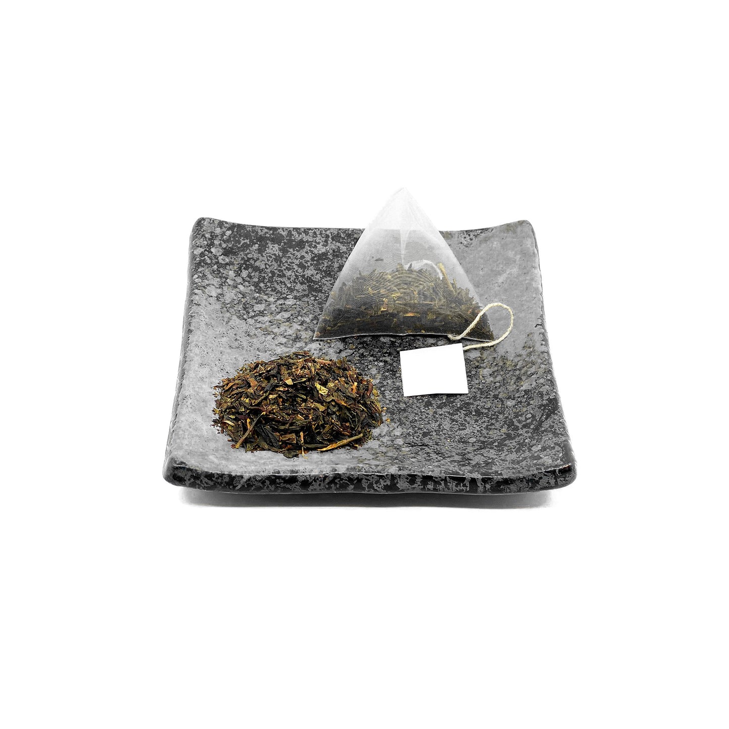 Premium Uji Wakocha tea bag and loose tea leaves from MAISON TOMOKI, beautifully arranged on a square vintage Hagi traditional ceramic plate, showcasing rich amber tones and authentic Japanese craftsmanship.